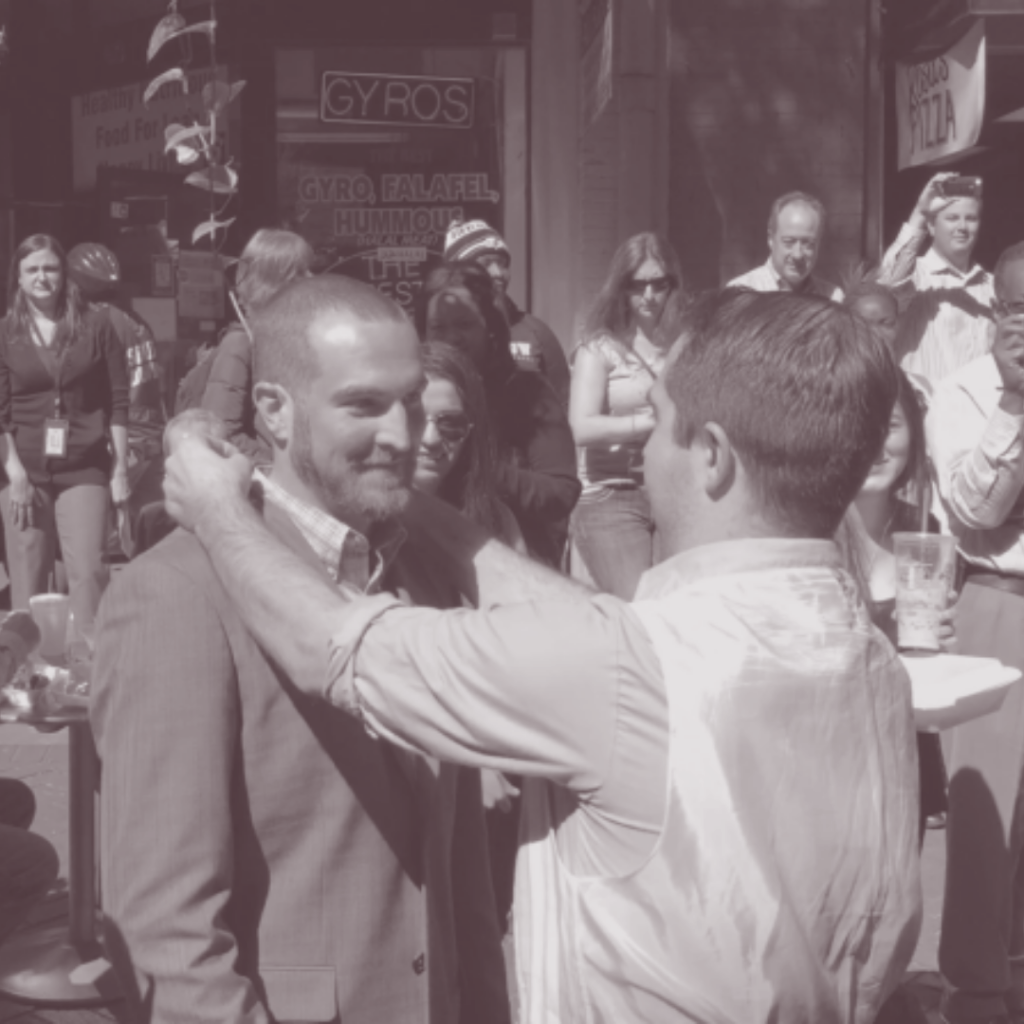 One person placing something around another person's neck