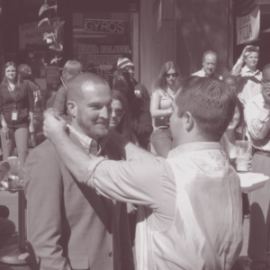 One person placing something around another person's neck