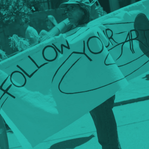 person holding "follow your art" banner